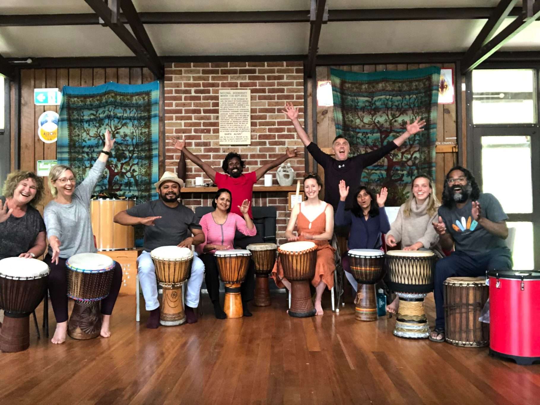 A group of happy retreaters pose with facilitators and african drums